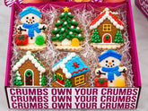 Six decorated winter cookies: two snowmen, a frosted tree and three mini gingerbread houses