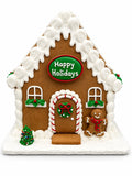 Front of the Happy Holidays gingerbread house with holly trim, a wreath on the candy-cane door and a small evergreen